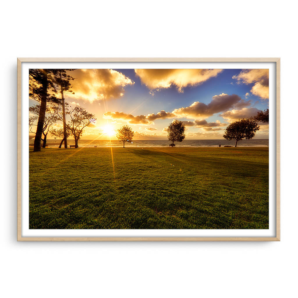 Golden sunset at City Beach in Western Australia framed in raw oak
