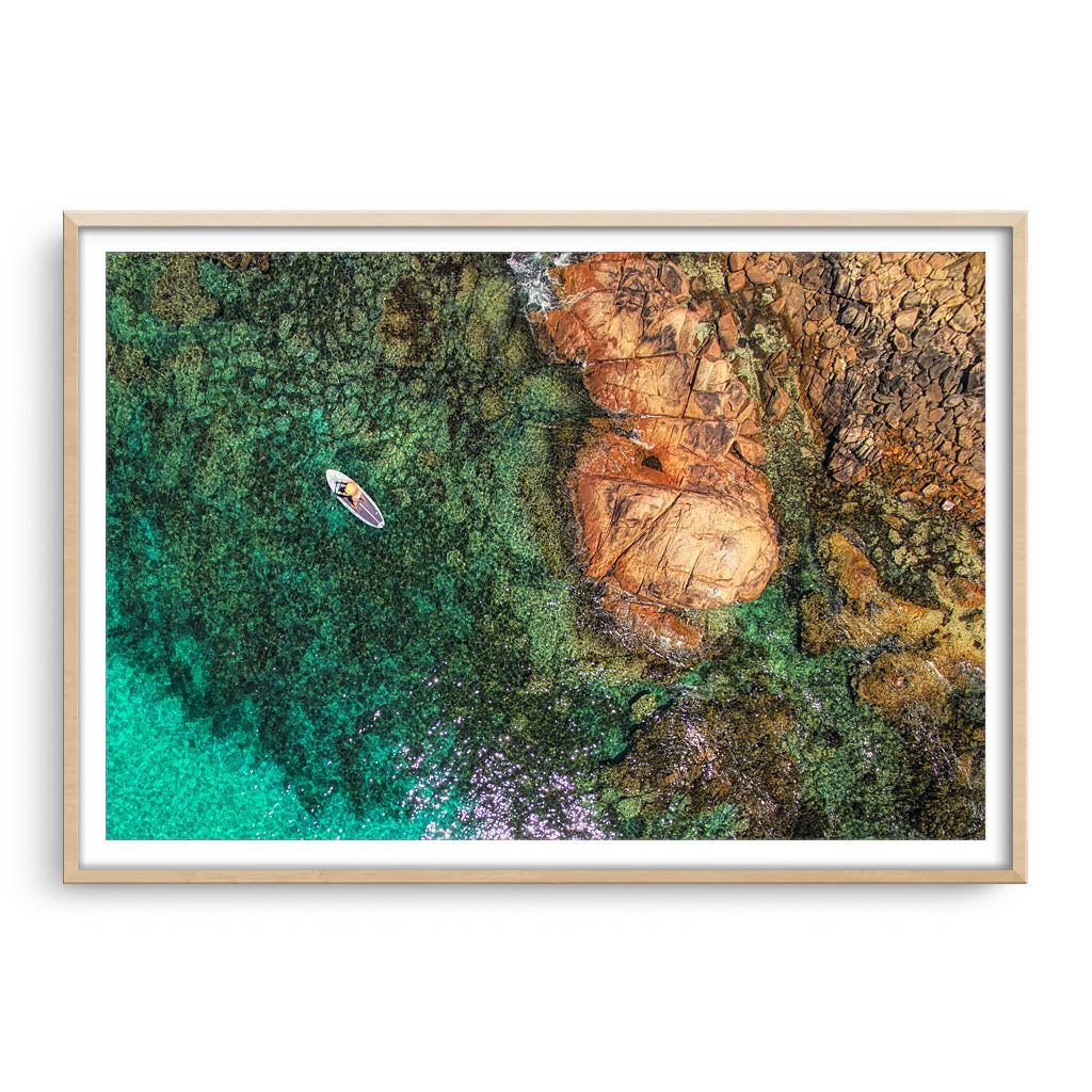 Aerial view of SUP at Meelup Beach in Western Australia framed in raw oak