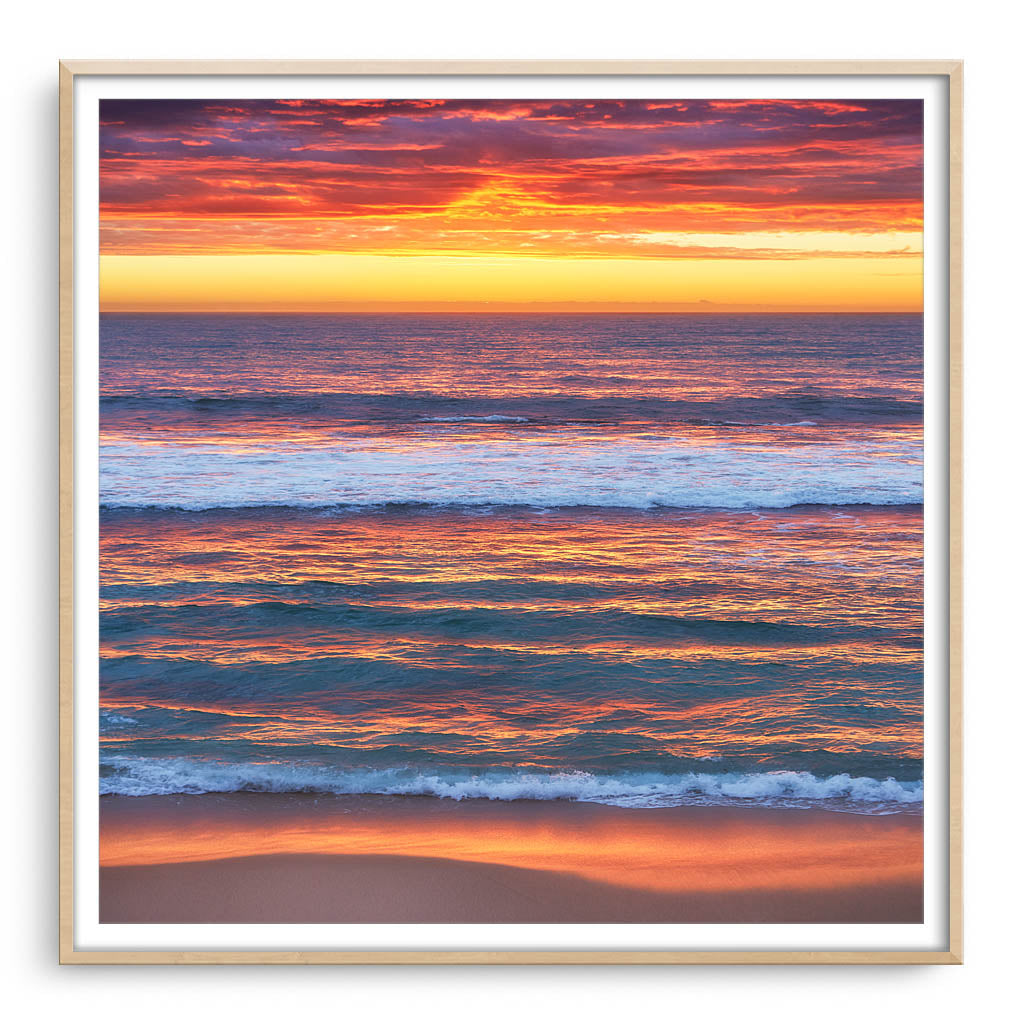 Multi-layered sunset at Mettams Pool in Perth, Western Australia framed in raw oak