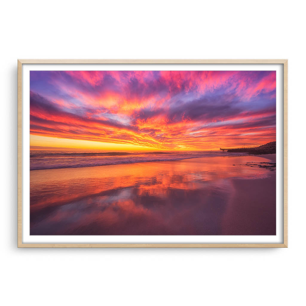 Rich, colourful sunset at North Beach in Western Australia framed in raw oak