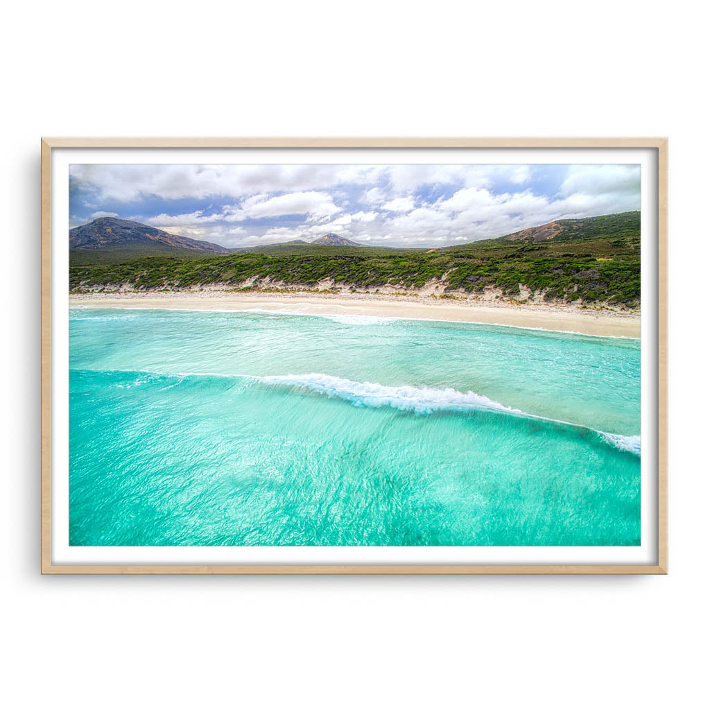 Aerial view of wave rolling into the beach at Hellfire Bay, Western Australia framed in raw oak