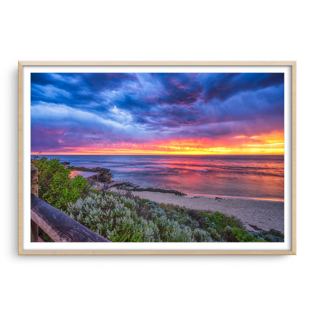 Colourful sunset over Mettams Pool in Perth, Western Australia framed in raw oak