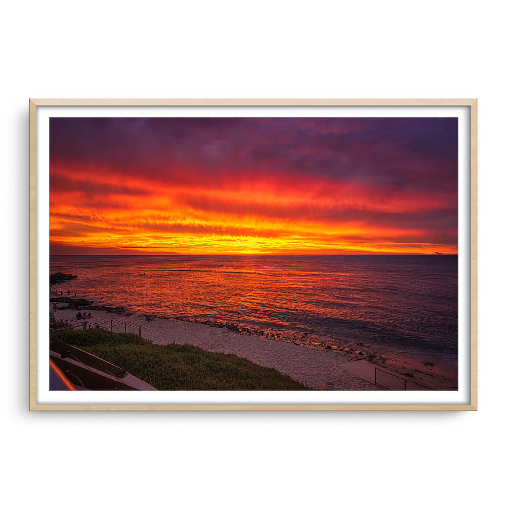 Fiery skies over Mettams Pool in Perth, Western Australia framed in raw oak