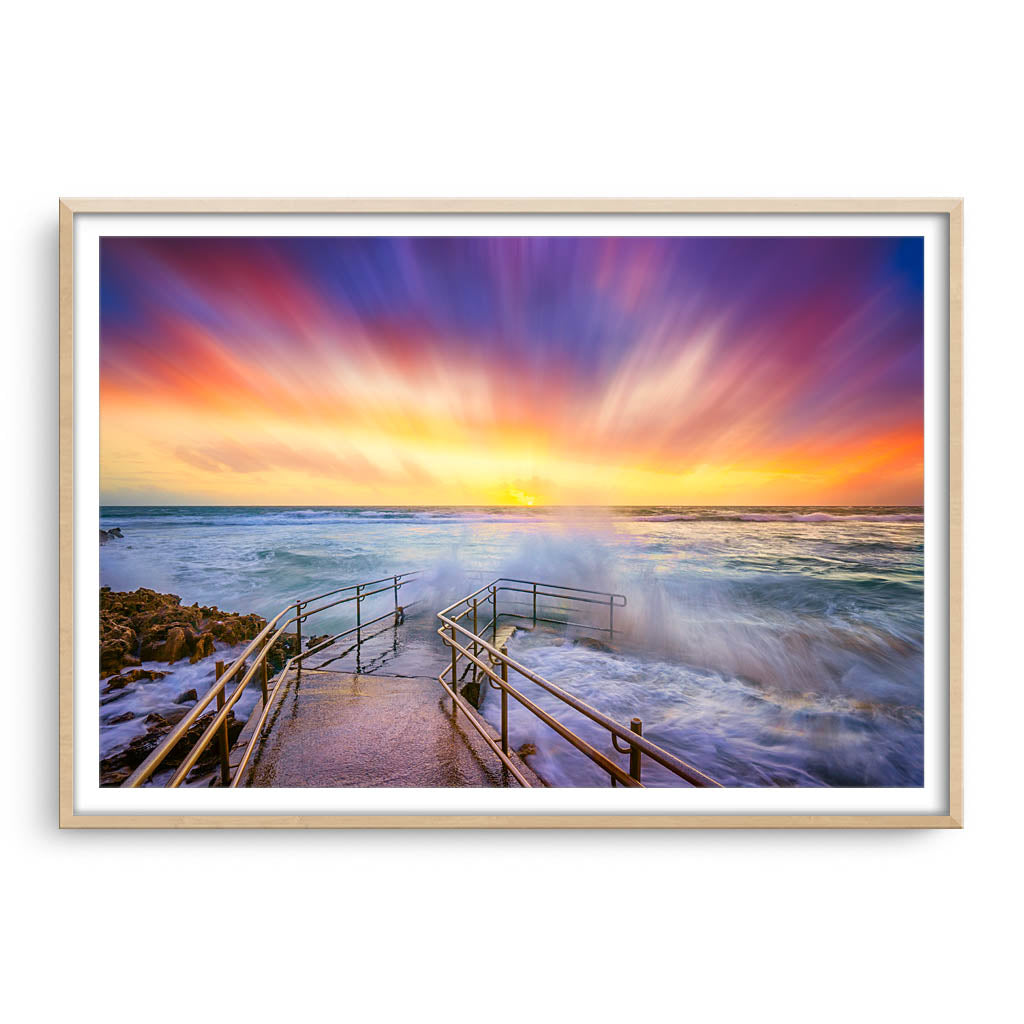 Colourful stormy sunset at Mettams Pool in Perth, Western Australia framed in raw oak