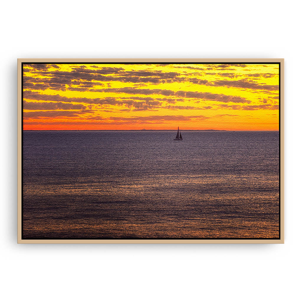 Boat sailing past rottnest island at sunset in Perth, Western Australia framed canvas in raw oak