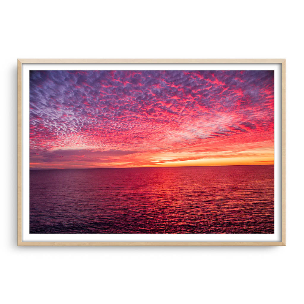 Sunset over the ocean at Mettams Pool in Perth, Western Australia framed in raw oak