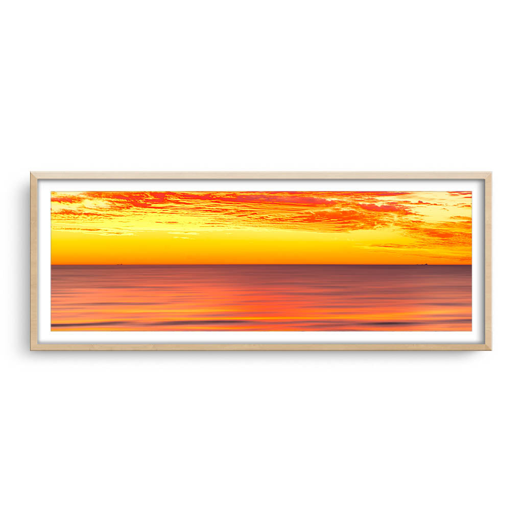 Golden skies over the ocean in Perth, Western Australia framed in raw oak