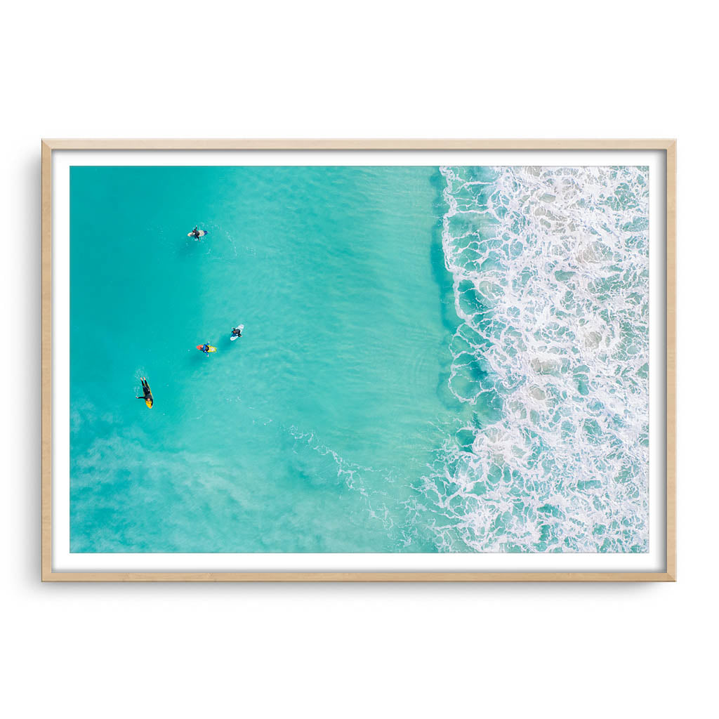 Surfers at Trigg Beach in Perth, Western Australia framed in raw oak