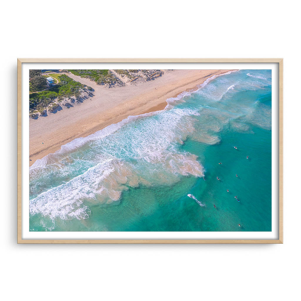 Aerial view of surfers at Trigg Beach in Perth, Western Australia framed in raw oak